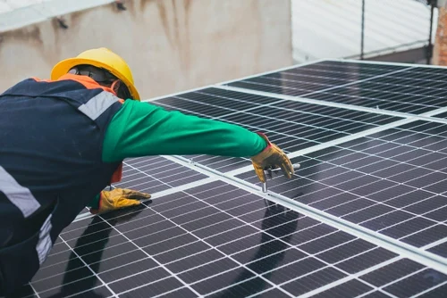 Technician repairing solar panel - XKJM Genset Solutions